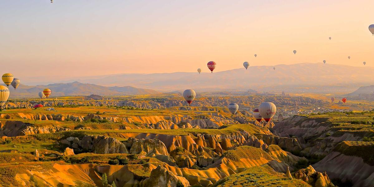Hot air balloons rising at sunrise — AI lifting off from datacentres onto personal devices