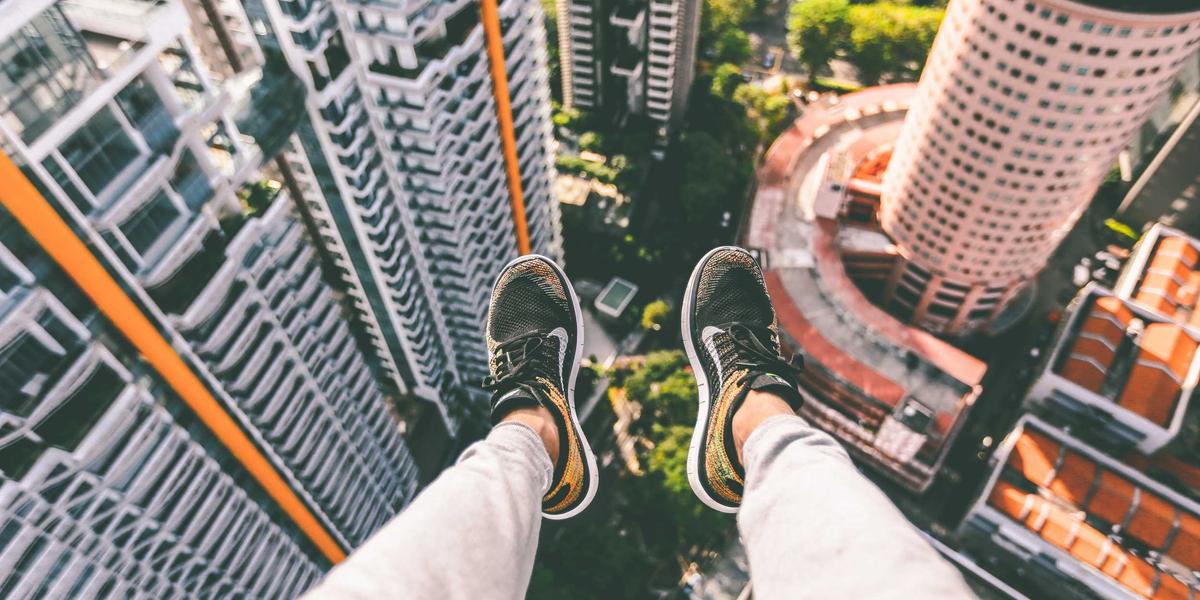 A person looking straight down from a skyscraper ledge — the vertigo of manipulative design