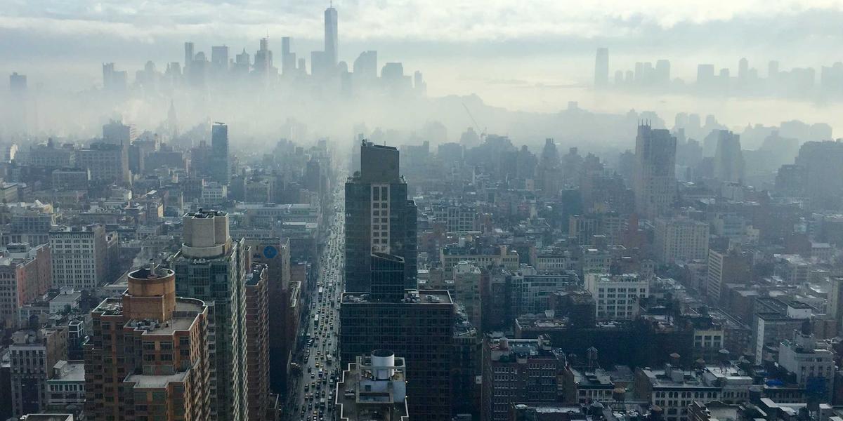 A city emerging from fog, seen from above — fast websites feel clear and immediate while slow ones stay hidden