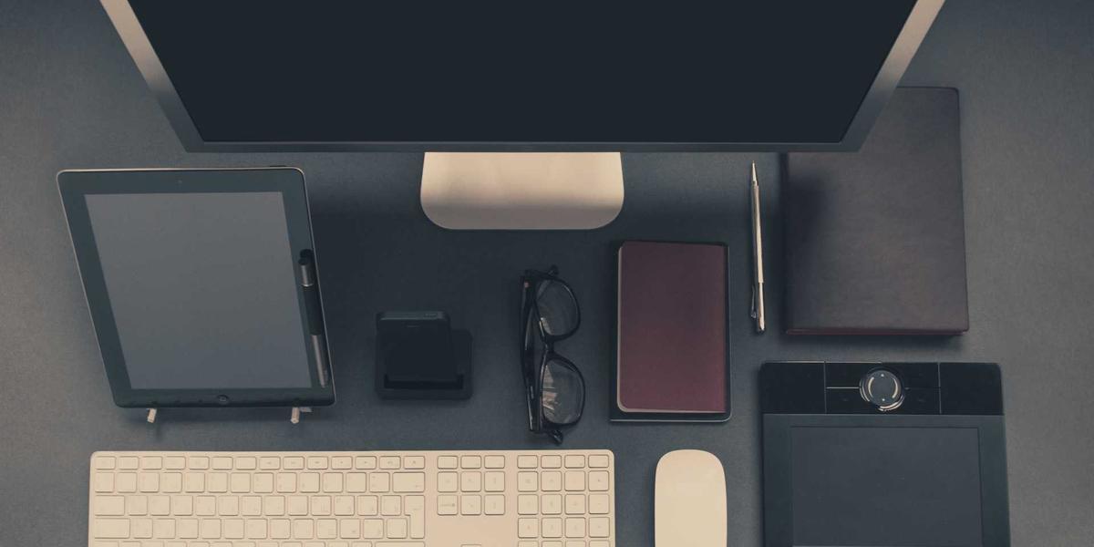 A dark desk setup with devices — password security starts with length and uniqueness