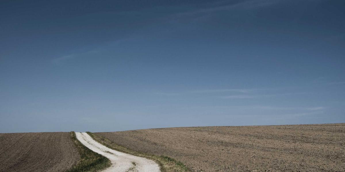 A long empty road crossing open plains — the journey a web request takes in milliseconds