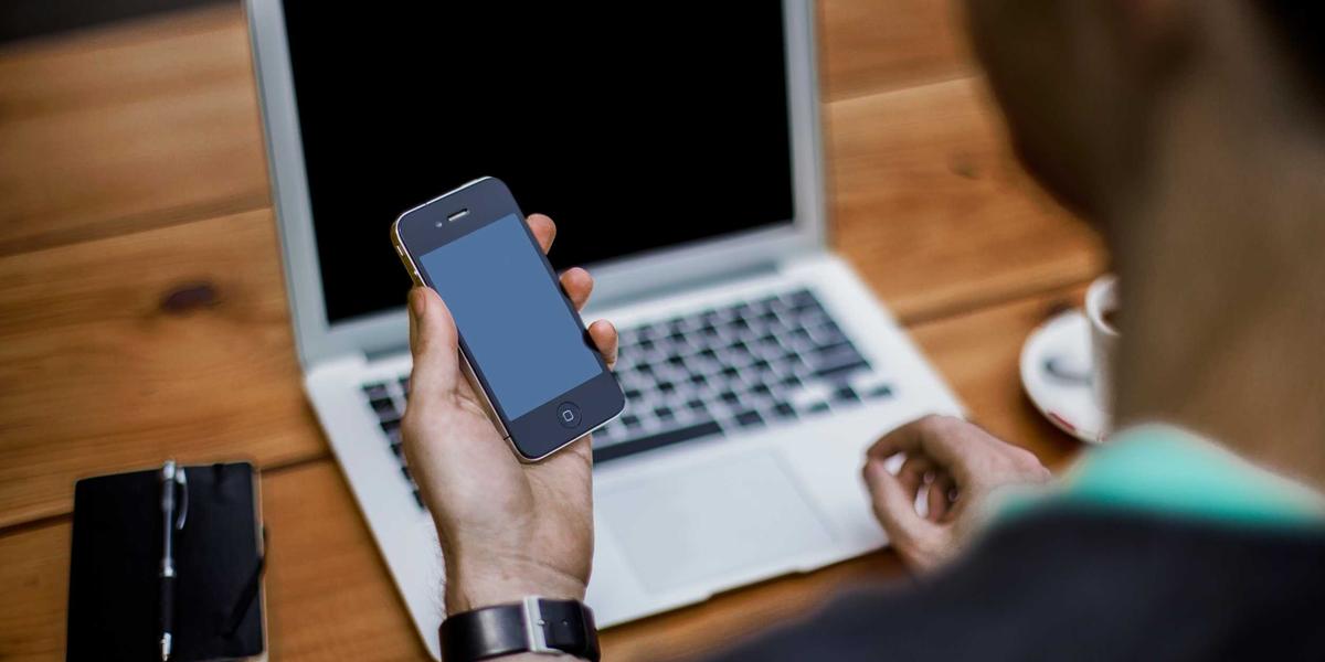 A hand holding a smartphone — scan QR codes only after checking where they lead
