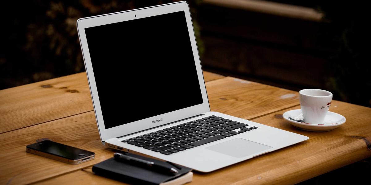 A laptop on a wooden desk with coffee — the browser now runs full applications locally